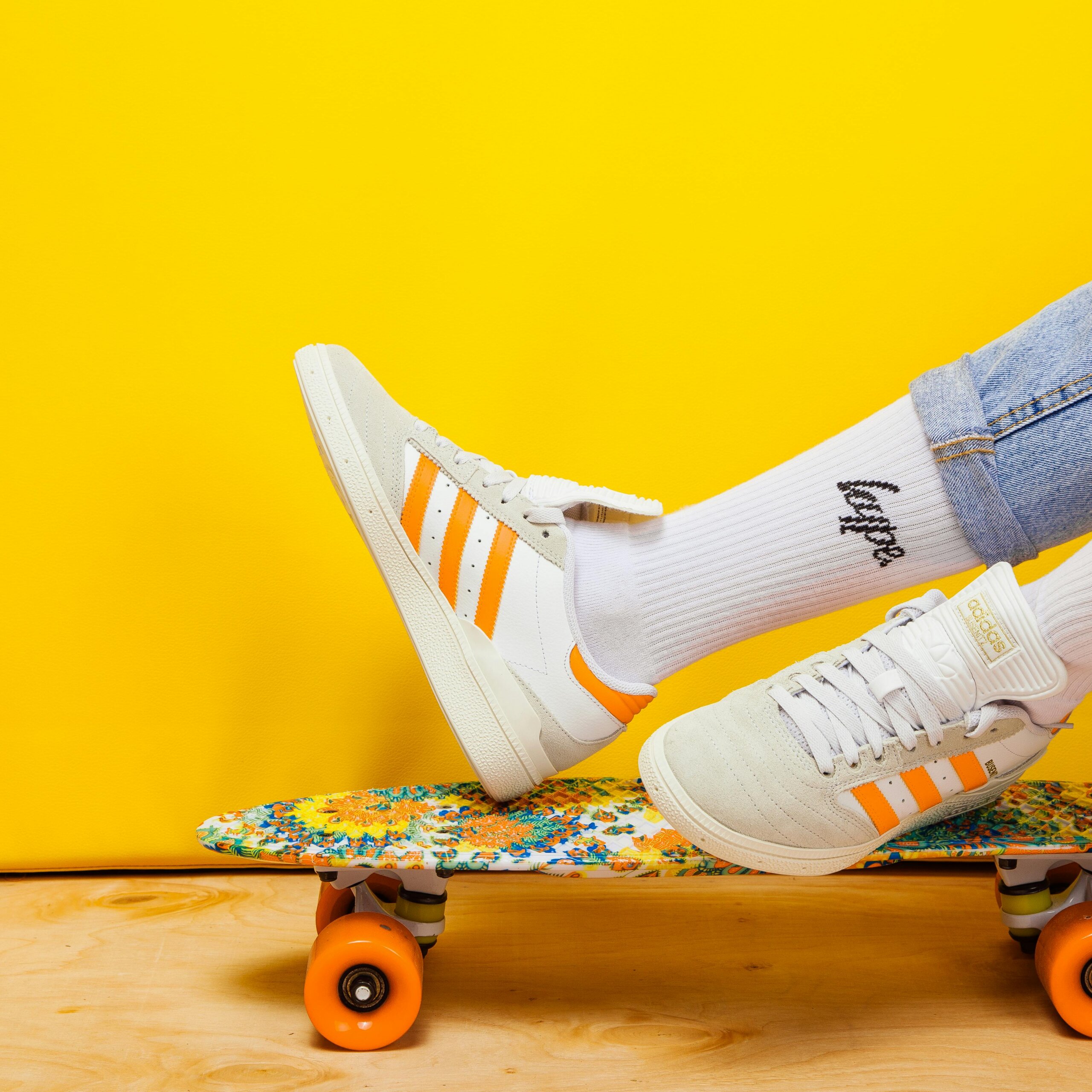 Shot focusing on pair of Adidas trainers worn by someone lying on a skateboard